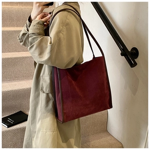 Nahaufnahme einer Vintage-Burgunder-Einkaufstasche aus Wildleder und Leder für Damen