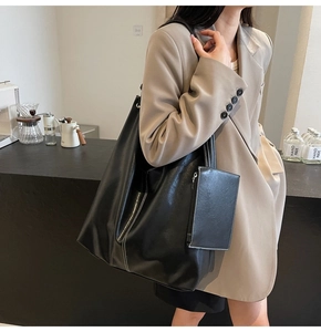 Dettaglio della grande borsa tote nera con cuciture bianche a contrasto e pochette