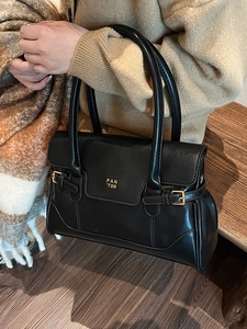 Elegant black leather underarm tote bag with gold metal buckle and branded finish