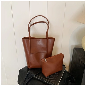 Brown leather bucket tote set with matching zipper pouch on a minimalist background