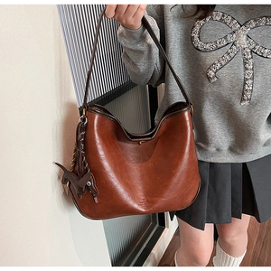 Detail of vintage brown tote bag with leather dachshund charm and embossed branding logo