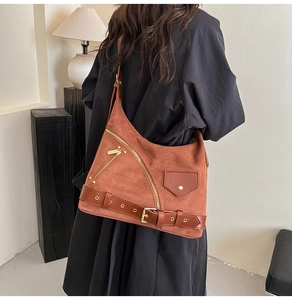 Detail shot of brown suede crossbody bag with vintage gold zippers and buckles