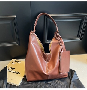 Gros plan du sac fourre-tout en cuir marron avec détails de coutures blanches contrastées