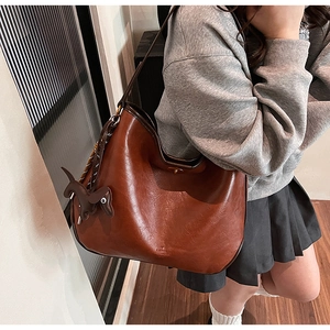 Brown vintage faux leather tote bag detail with wide strap and cute puppy pendant accessory
