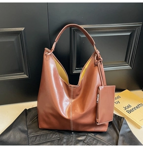 Détail d'un cabas vintage en cuir rouge avec intérieur jaune et mini pochette