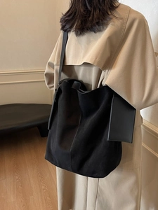 Minimalist large black suede tote bag for women worn by model in trench coat