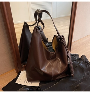 Détail du grand sac cabas en cuir marron foncé avec surpiqûres blanches et doublure jaune