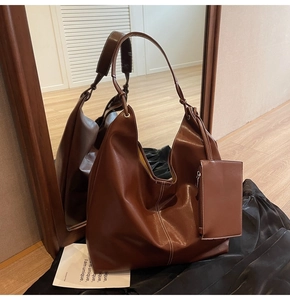 Sac hobo en cuir marron avec coutures blanches contrastées et petite pochette pendante