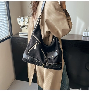 Detail of vintage black suede dumpling bag featuring punk style rivets and hardware zippers