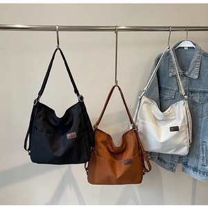 Detailed display of high-capacity canvas tote bags in black, brown, and white colors