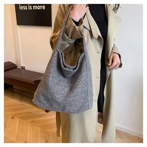 Detail of grey felt wool tote bag showing thick fiber texture and minimalist soft silhouette