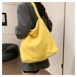 Detailed view of the yellow faux fur tote bag texture on a model's shoulder for winter