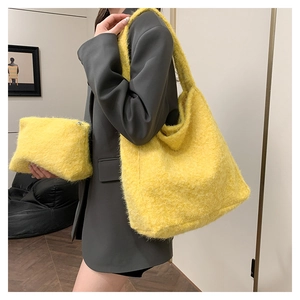 Detail of yellow wool tote bag set with wide strap and matching pouch on a model shoulder