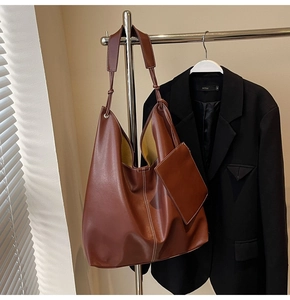 Détail d'un grand cabas en simili cuir marron avec surpiqûres blanches et pochette ronde