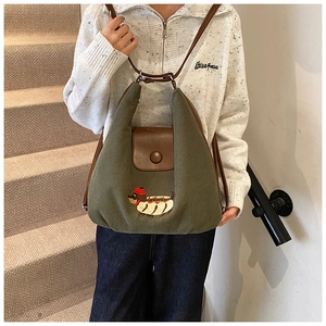 Dettaglio borsa hobo in velluto verde con ricamo creativo di bassotto e tracolla in pelle