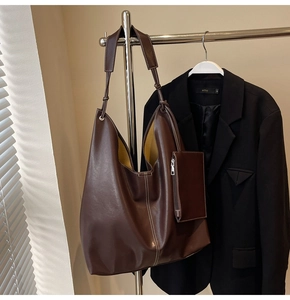 Détail d'un grand sac cabas hobo marron avec surpiqûres blanches et une pochette zippée interne