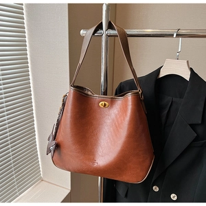 Nahaufnahme der braunen Vintage Leder-Tote mit goldenem Drehverschluss und Markenlogo