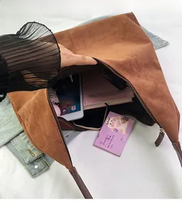 Top view of spacious interior in a brown matte tote bag storing a tablet and cosmetics