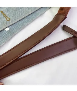 Close-up of a brown leather shoulder strap with durable double stitching and smooth edges