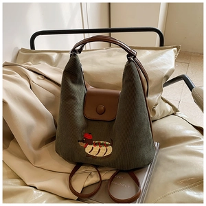 Dettaglio borsa tote in velluto a coste verde scuro con ricamo di bassotto carino