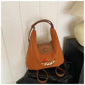 Dettaglio della borsa a spalla vintage in velluto marrone con ricamo a bassotto
