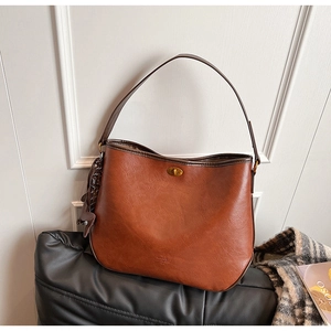 Detail of vintage brown textured leather shoulder bag with elegant golden twist lock