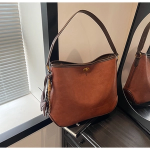 Detail of vintage brown shoulder bag showing metal twist lock and leather texture