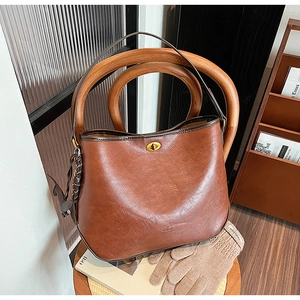 Close-up of vintage brown bucket bag with golden twist lock and textured finish