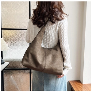 Brown matte suede hobo bag shown from back view on model for size perspective