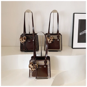 Close-up of contrast tote bags with animal prints and heart plush charms on display