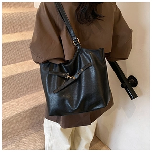 Detailed back view of a large black vintage tote bag worn over the shoulder for daily commuting