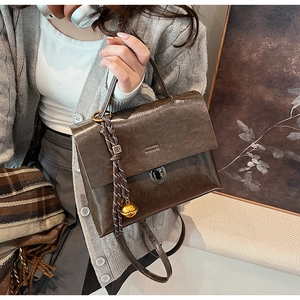 Détail du sac à main en simili cuir marron foncé avec boucle en métal et cordon tressé