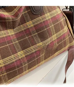Détail de la texture rétro à carreaux avec bandoulière en cuir brun et boucle