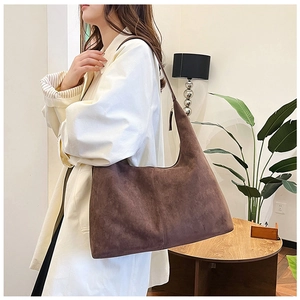 Detail of a large vintage brown faux suede tote bag worn on a shoulder for daily commute