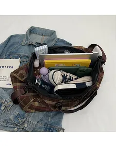 Vue de dessus de l'intérieur spacieux d'un sac de voyage à carreaux marron avec effets