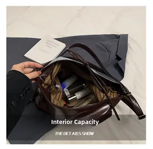 Internal capacity of dark brown tote bag showing striped lining and zip pocket
