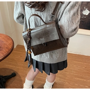Details einer vintage dunkelbraunen Handtasche aus Kunstleder mit Retro-Metallschließe