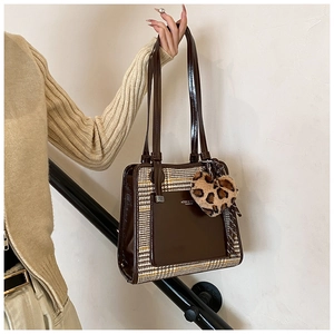 Detail of contrast stitching tote bag with houndstooth pattern and heart charm
