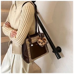 Detail of color-block tote bag with plaid texture and leopard print heart charm decoration