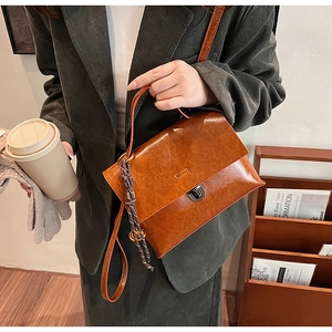 Détail du sac à main vintage en cuir marron avec boucle en métal et décor tressé