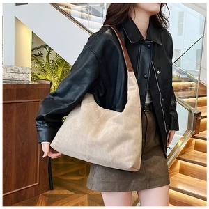 Detail view of beige matte PU shoulder bag with stitching and brown leather strap