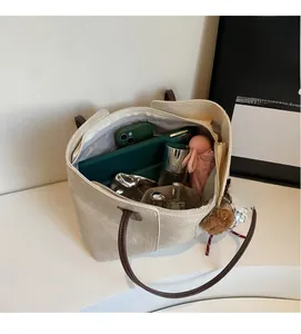 Spacious interior of beige canvas tote showing items like tablet and daily essentials
