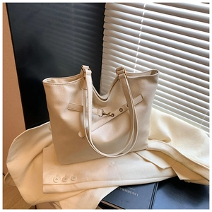 Detail of cream white tote bag featuring premium faux leather texture and metal hook buckle