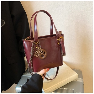 Sac seau en cuir bordeaux profond avec pendentif boulier vintage doré élégant
