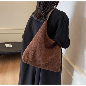 Détail du sac cabas en peluche marron montrant la texture douce sur l'épaule