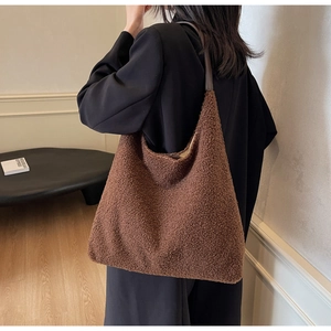 Gros plan d'un grand sac fourre-tout marron en peluche avec des lanières en cuir