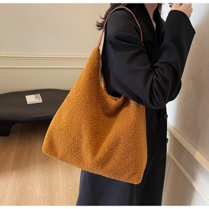 Détail du grand sac cabas en laine d'agneau marron avec des anses en cuir brun foncé