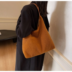Vue latérale d'un grand sac cabas en peau de mouton caramel avec des anses en cuir brun