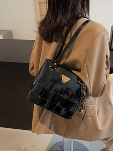 Bolso tote negro de cuero trenzado con logo triangular dorado y borla lateral