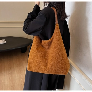 Détail du sac cabas en peluche caramel porté épaule montrant la texture douce en laine